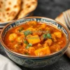 A bowl of spicy Indian curry with naan bread