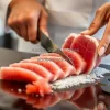 A chef cutting fresh tuna for sashimi