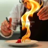 A chef flambéing a dessert with flames