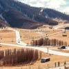 A deserted ski resort without snow chairlifts hanging over bare brown slopes