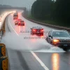 A highway with one lane underwater as cars drive through splashing climate emergency