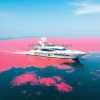A luxury yacht in a red algae bloom sea unsettling juxtaposition