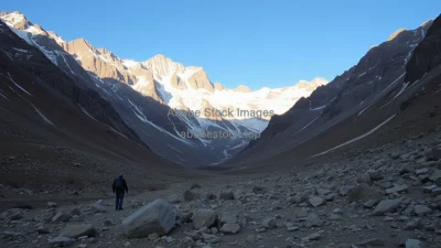 A mountain valley once snowy now dry with exposed rocks hikers looking concerned