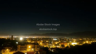 A night scene of a blackout city lit only by stars and a few solar lamps