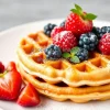 A plate of fluffy waffles topped with berries