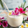 A tropical coconut drink with flowers and ice