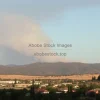 A wildfire smoke plume reaching high into the sky seen from a nearby town