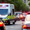 Ambulance weaving between cars on a busy city avenue sirens on
