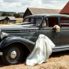 Antique car at a countryside wedding with hay fields and barns around