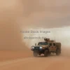 Armored military vehicle on a desert road sandstorm approaching dramatic sky