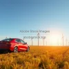 Car driving through a field of wind turbines renewable energy concept