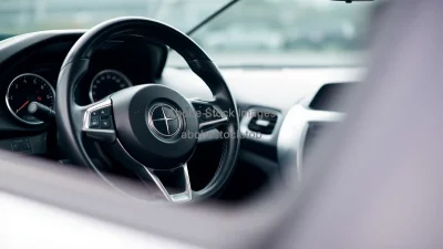Car interior detail of steering wheel and dashboard shallow depth of field