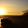 Car on a racetrack at sunrise pit building silhouettes warm backlight