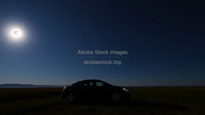 Car parked under a glowing full moon in open countryside starry sky