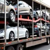 Car transporter truck loaded with new vehicles on a highway industrial scene