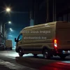 Cargo van making night deliveries in a dimly lit industrial area gritty look