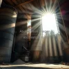 Cement factory interior with massive silos dust particles in sunbeams heavy industrial feel gritty realism