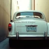 Classic car stuck in a narrow alley barely fitting humorous situation