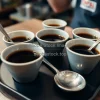 Coffee cupping setup with multiple cups and spoons