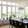 Dining room with wall of windows and row of potted plants on sill