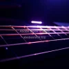 Electric guitar strings vibrating under strobe light physics of sound and resonance dramatic close up