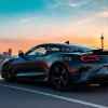 Electric sports car on a rooftop parking lot city skyline sunset background