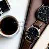 Espresso in tiny cup next to vintage wristwatch and notebook