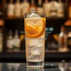 Espresso tonic in clear glass with ice and orange slice
