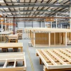 Factory producing modular homes interior view of assembly of walls floors and roofs organized workflow