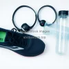 Flat lay of running shoes headphones smartwatch and water bottle