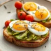 Healthy avocado toast with eggs and cherry tomatoes on a rustic plate