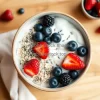 Healthy breakfast bowl with oats yogurt fresh berries and chia seeds on a wooden table