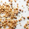 Healthy homemade granola spread out on baking paper with nuts and seeds