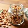 Healthy nut and seed mix in a glass jar on a wooden table