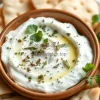 Healthy yogurt dip with cucumber and herbs served with pita