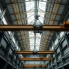 High bay industrial hall with overhead cranes moving heavy steel beams dramatic perspective wide angle