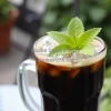Iced black coffee with mint garnish
