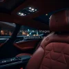 Luxury car interior leather seats ambient lighting shot from backseat