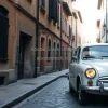 Old European car in a narrow cobblestone street with historic buildings around soft morning light