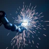 Robotic arm welding bicycle frames bright sparks flying minimal background industrial style